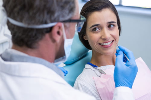 Patient smiling while receiving dental treatment from a dentist accepting the Canadian Dental Care Plan.