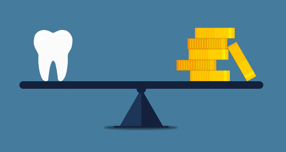 Tooth balanced with gold coins illustrating cost versus value of dental crowns